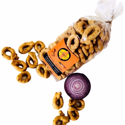 Top view of a transparent bag of Giannetti Artisans onion taralli on a white background with a red onion and loose crackers