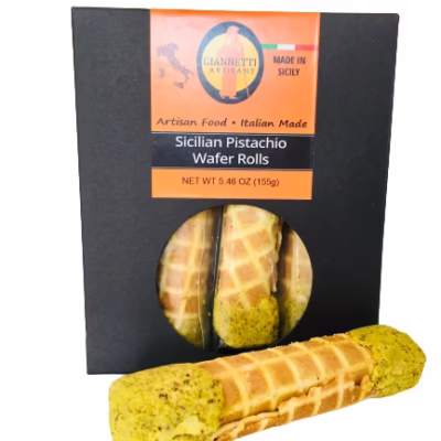 Giannetti Artisans Sicilian Pistachio Wafer Rolls in black packaging with an individual roll in front, showcasing the pistachio-filled ends.