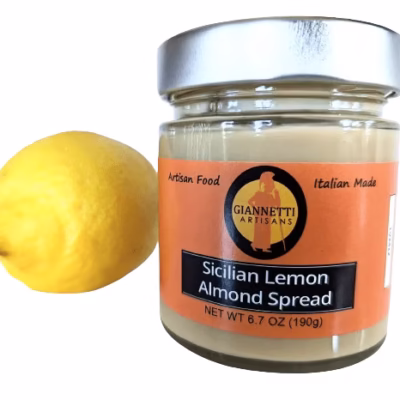 Front view of a Giannetti Artisans 7 oz jar of Sicilian Lemon Almond Spread with lemon prop on a white background