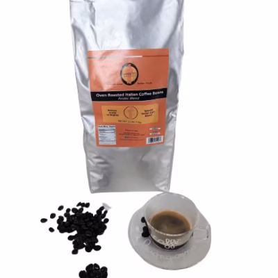 Front shot of one bag of Giannetti Artisans 70% arabica espresso beans with the actual beans and espresso cup as props next to the bag on a white background