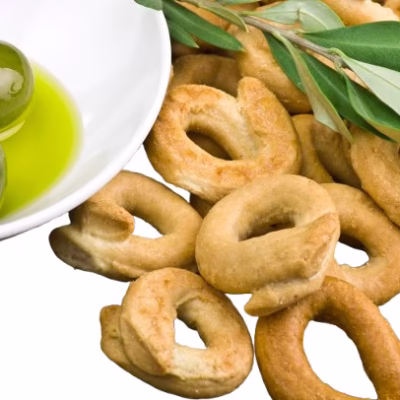 Close up of Artisan Taralli sold by Giannetti Artisans with olive oil and olive leaves