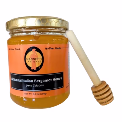 7 oz jar of Giannetti Artisans Italian Honeysuckle Honey with wooden honey dipper