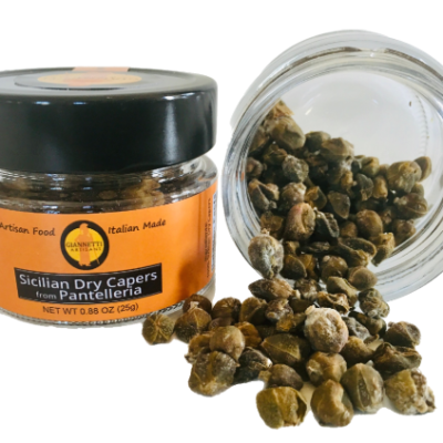 A close up of a jar of Giannetti Artisans Sicilian Dry capers with another jar that displays the actual dried capers pouring out